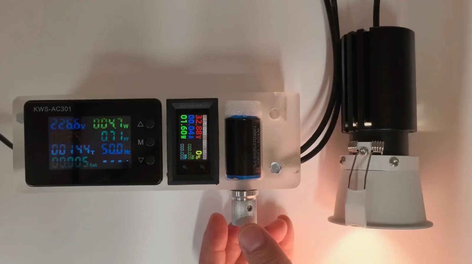 Adjustable LED driver showing voltage, current and output parameters while testing a recessed spotlight