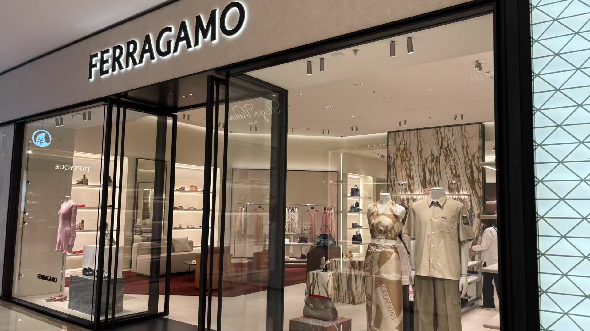 Downlight installed in Ferragamo Boutique in an unidentified location, showing Ferragamo boutique entrance with mannequins and recessed spotlights.