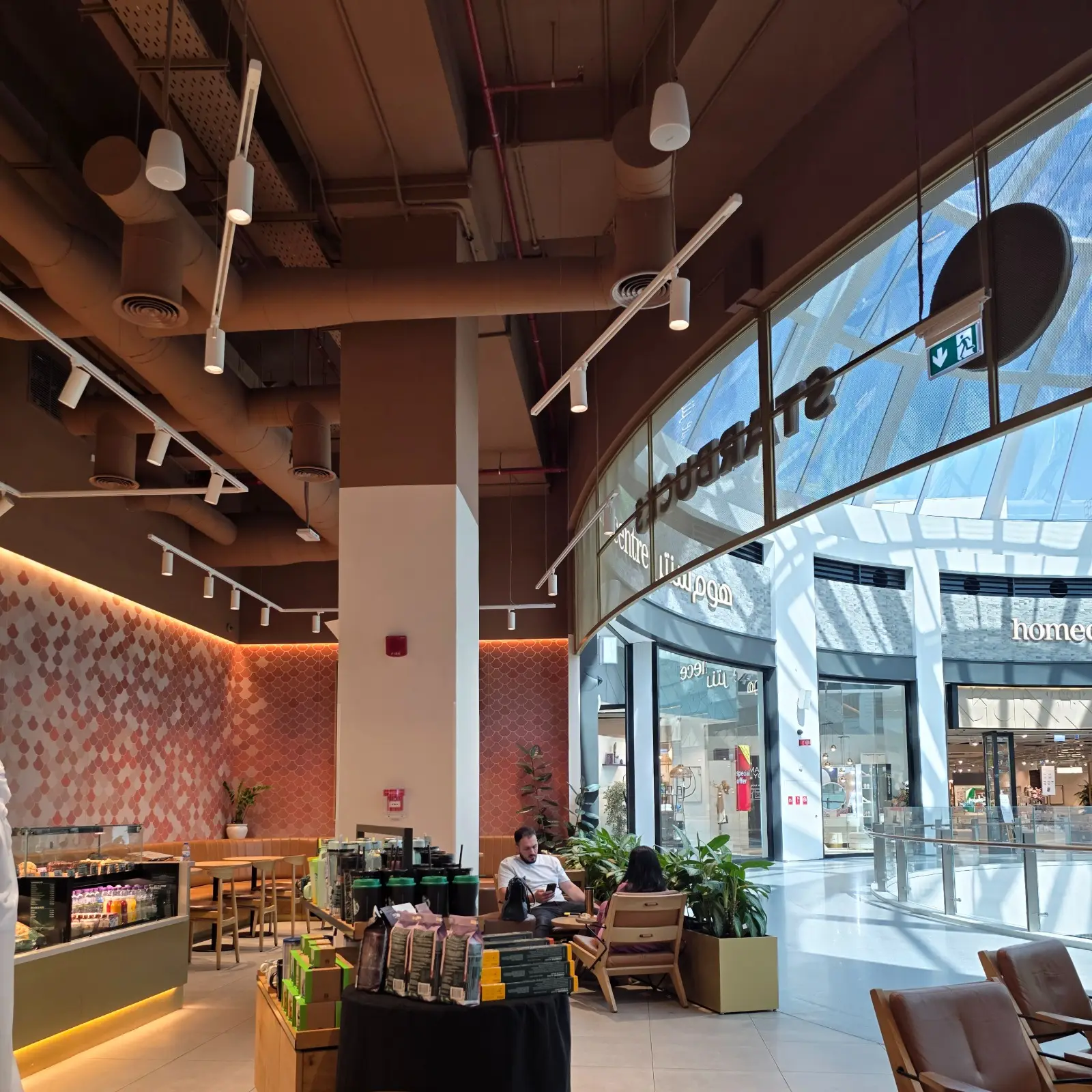 Track Lighting installed in a restaurant project in the Middle East, showing cafe seating area with exposed ceiling and white track lighting.