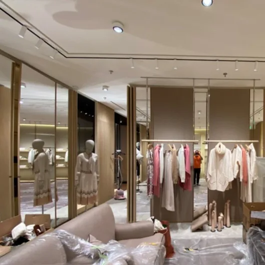 Track lights illuminating the Loro Piana luxury window display with precise accent lighting.